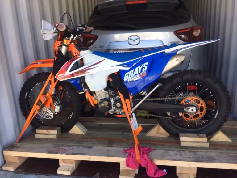Motocross bike strapped down inside a shipping container