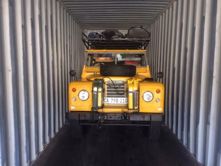 Yellow Land Rover loaded in a shipping container